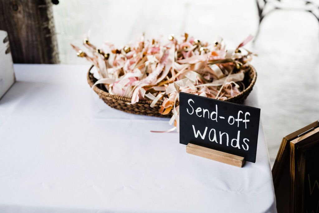 A basket of home made wands with a sign in front that says "Send-off wands".