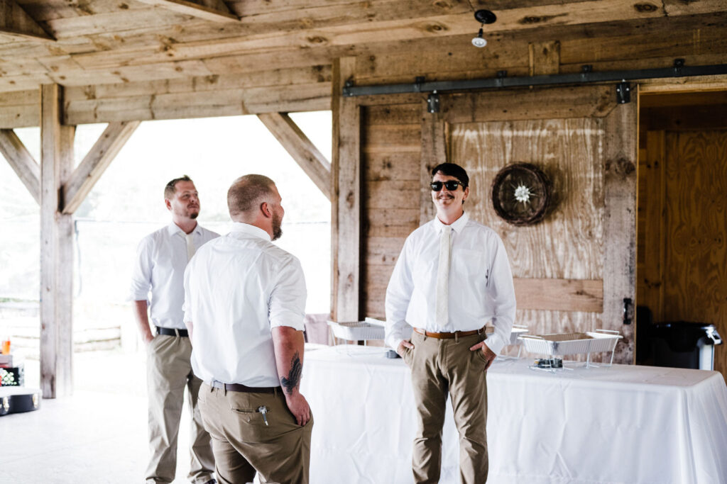 A groom and his wedding party talking together.