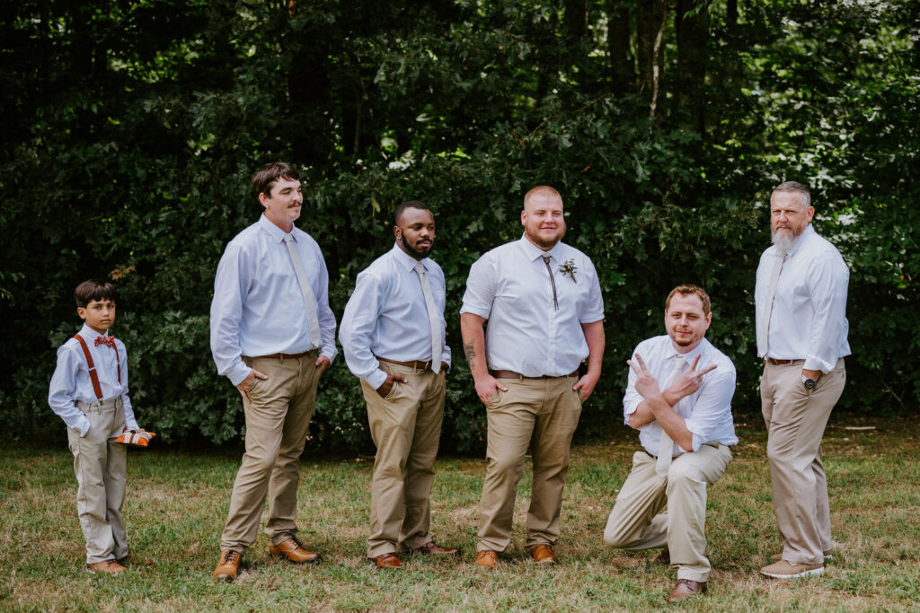 A groom and his wedding party posing together.