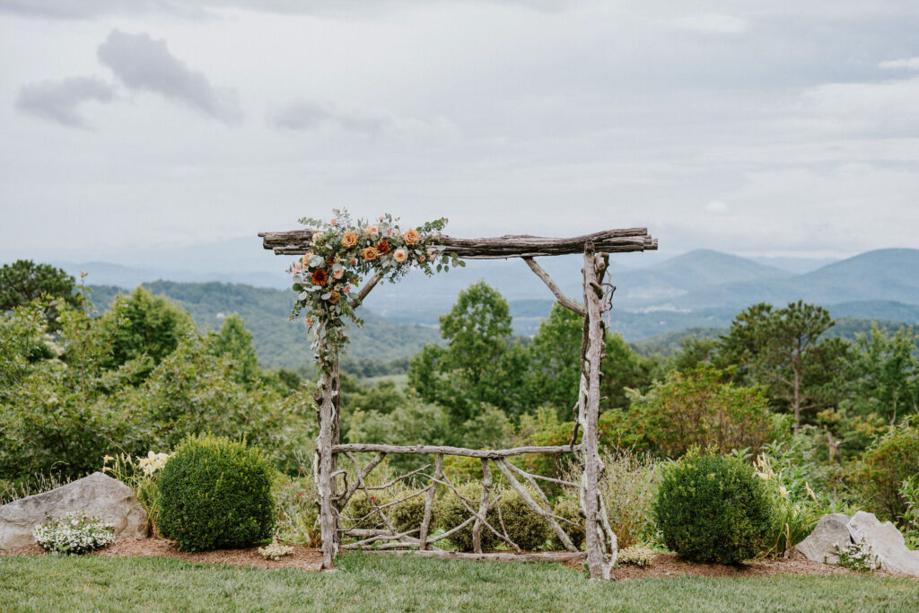A small wooden arch with flowers in the left corner. 