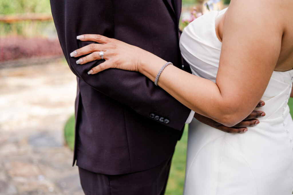 A close up view of a wedding couple's arms around each other. 