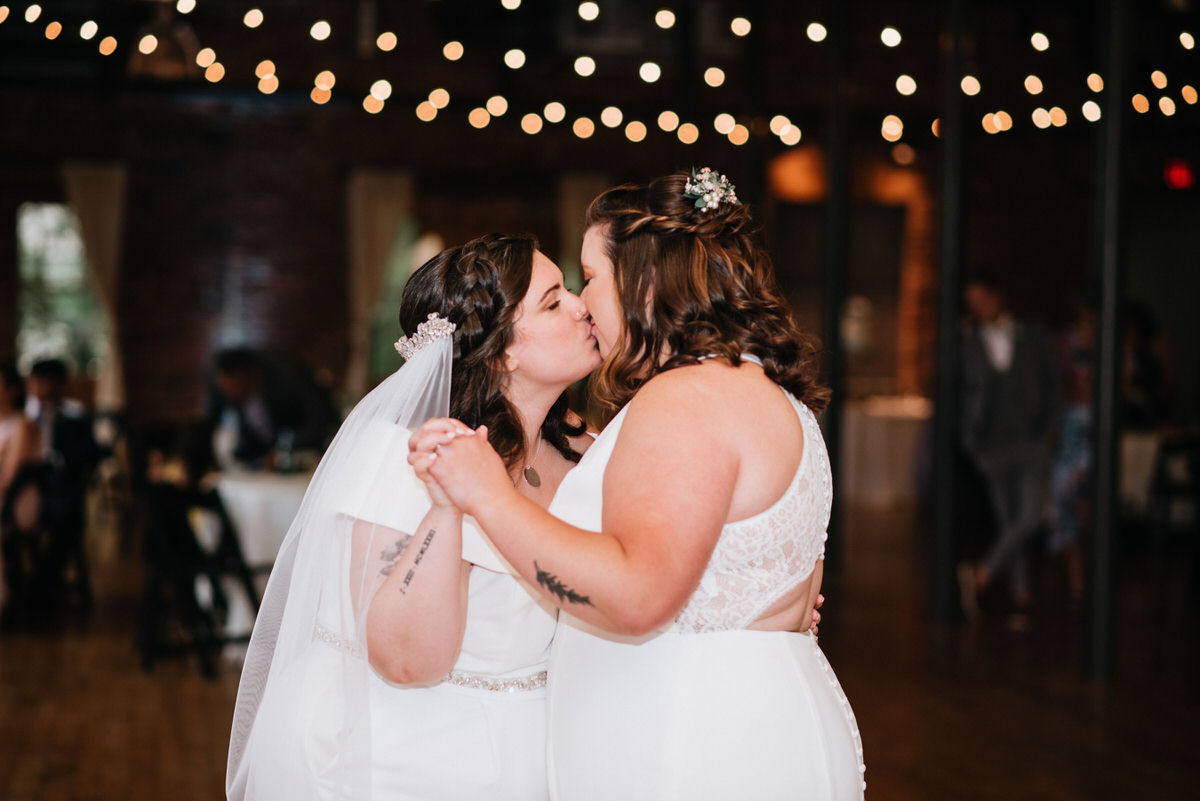 Two brides kissing during their first dance at one of the best LGBT friendly wedding venues in South Carolina.