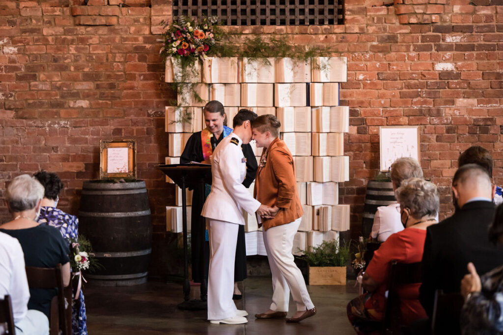 A couple leaning in for a kiss during their wedding ceremony. 