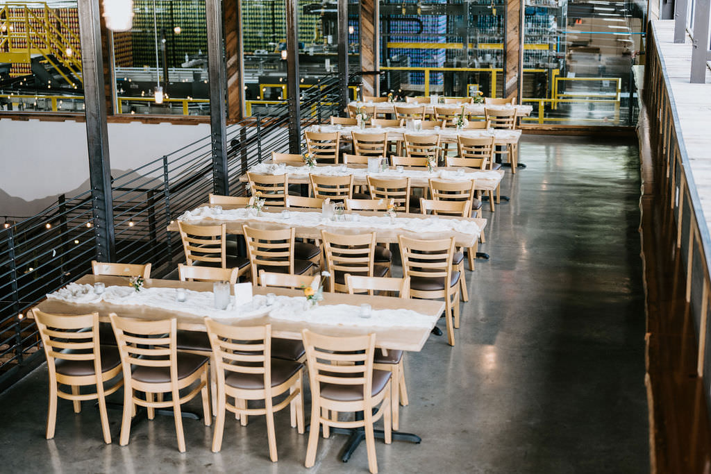 Rectangular tables set up in rows in an industrial style space at the Highland Brewing Company. 