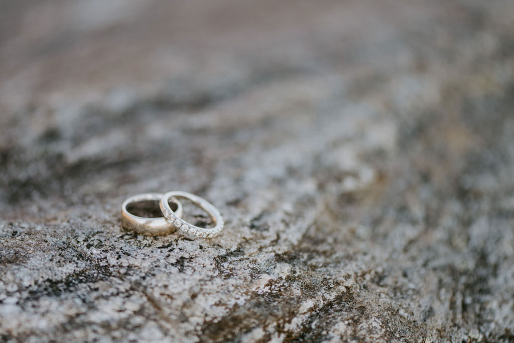 Close-up of two engagement rings on a rock. 