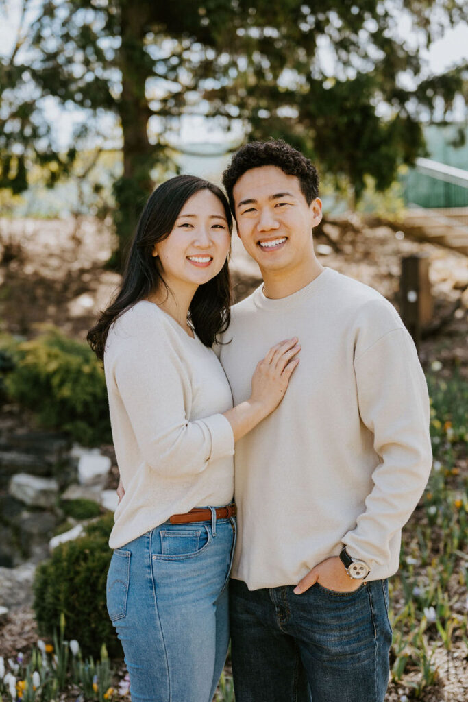 A person with their hand on their partner's chest as they both smile. 
