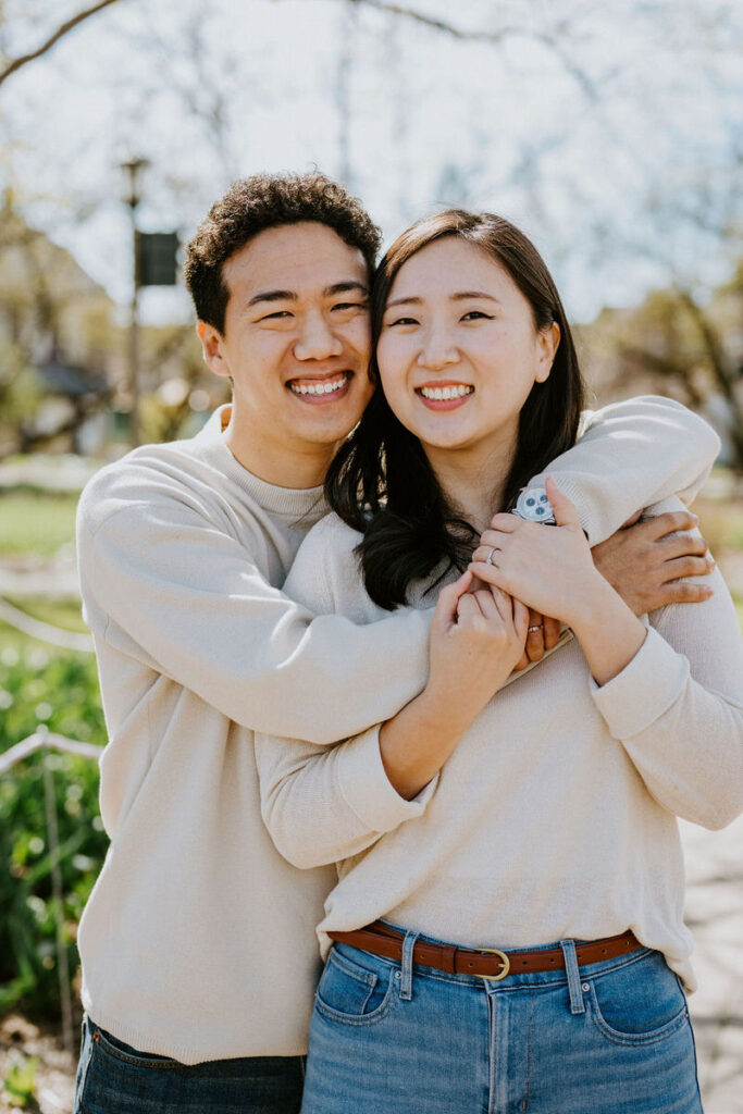 A person with their arms around their partner as they both smile. 