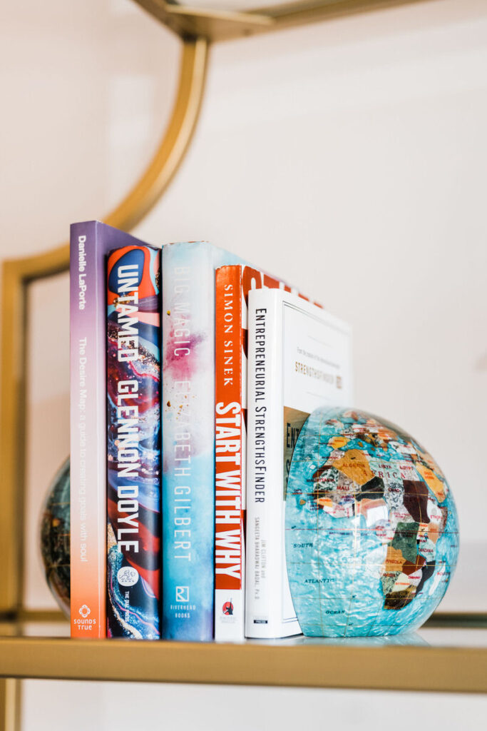A stack of books held up by globe shaped book ends 