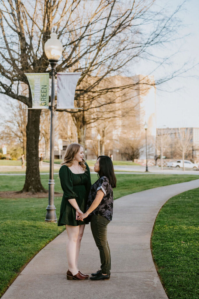 A couple holding hands and smiling together on a small path 