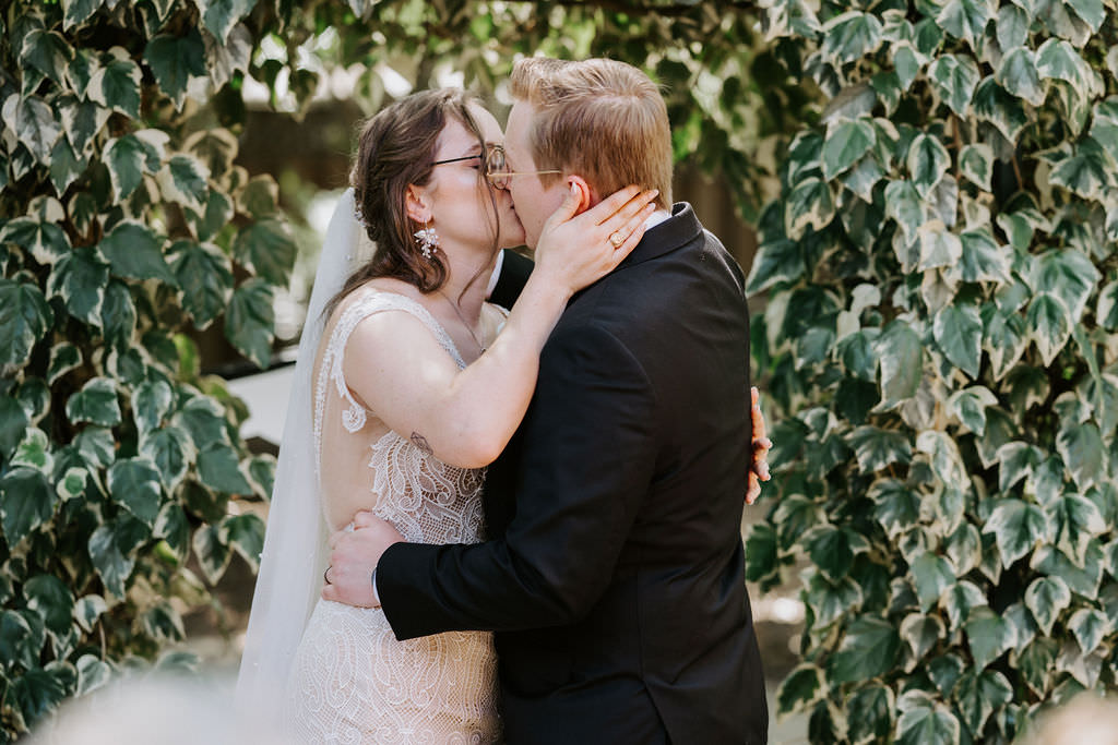 A wedding couple during their first kiss 