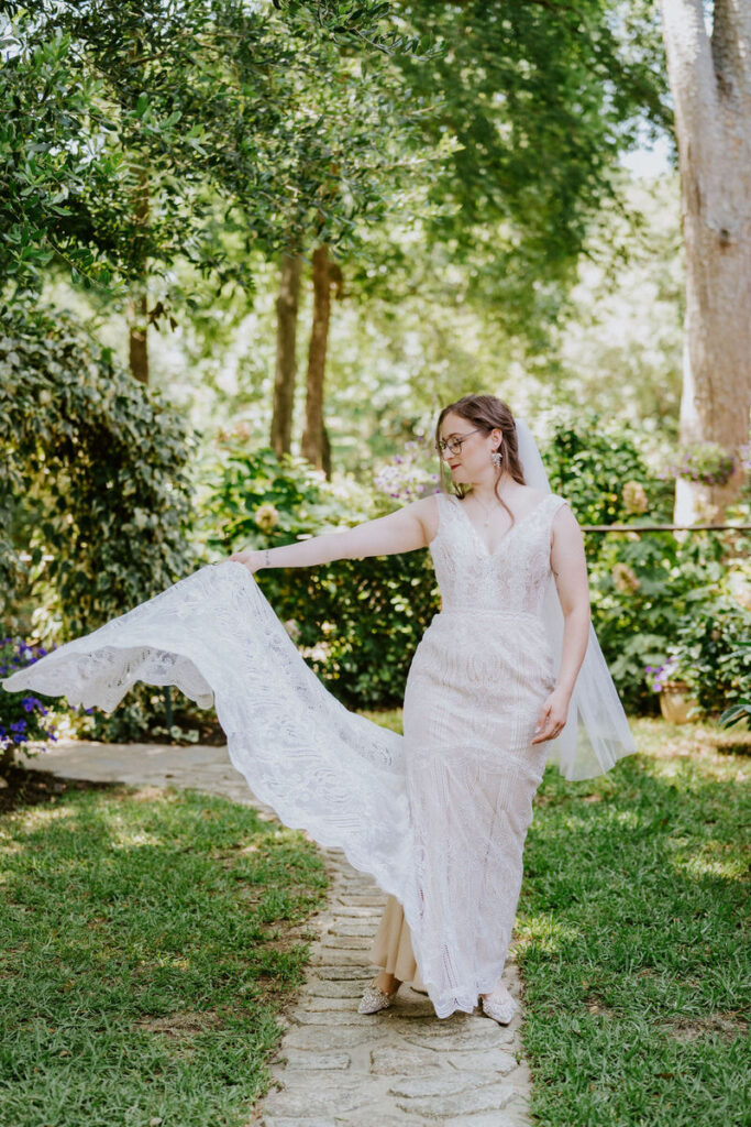 A newlywed holding out one side of their dress 