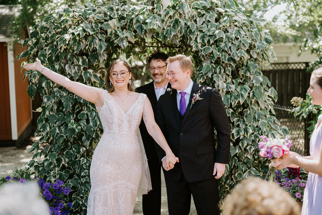 A newlywed couple celebrating together after saying their vows 
