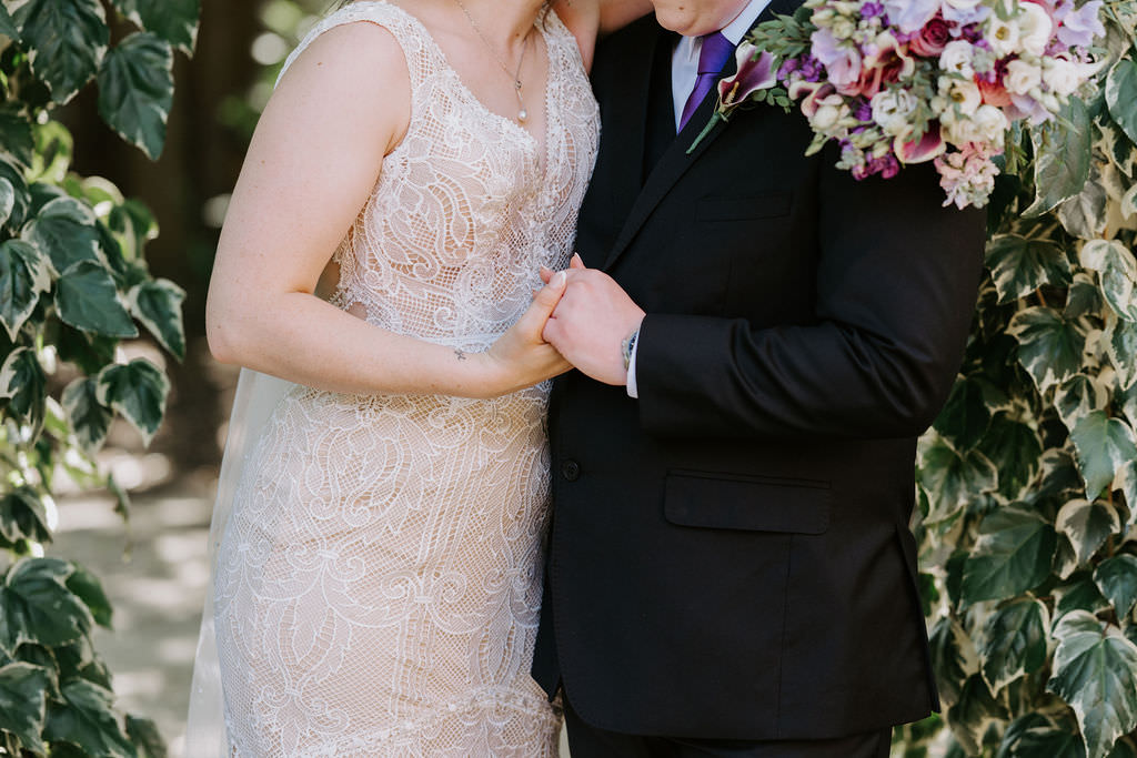 Close up of a wedding couple holding hands