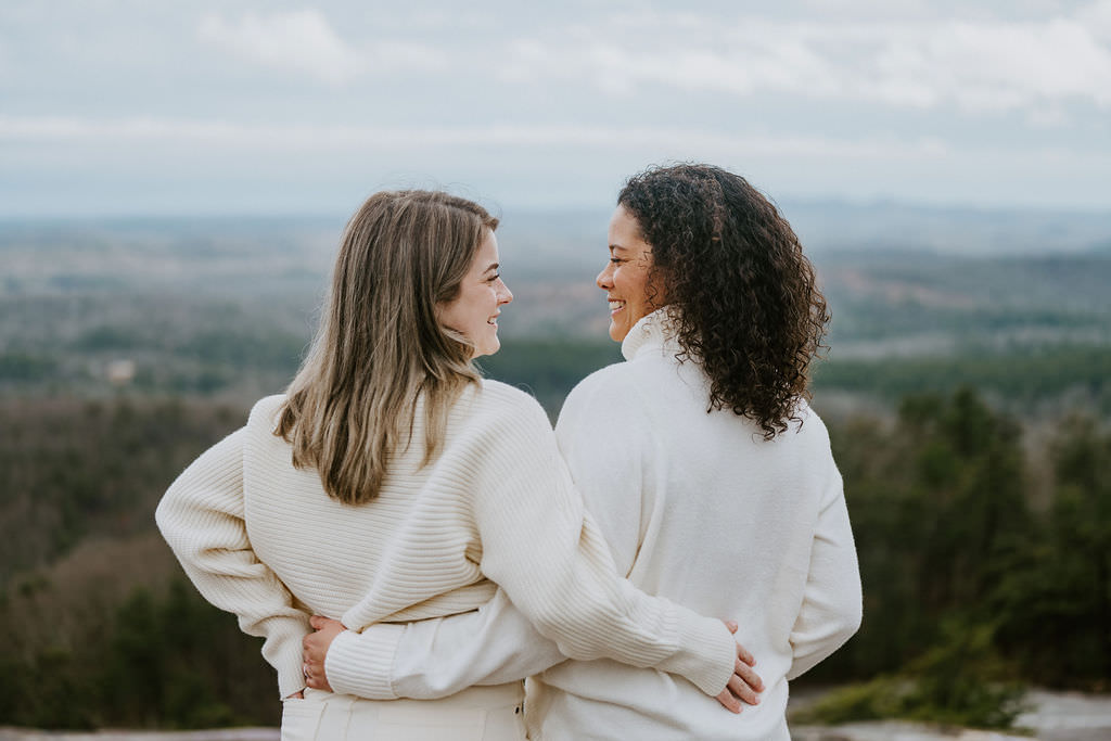 Two people with their arms around each other smiling