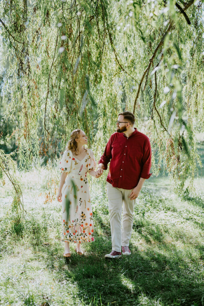 A couple holding hands and walking outside together. 