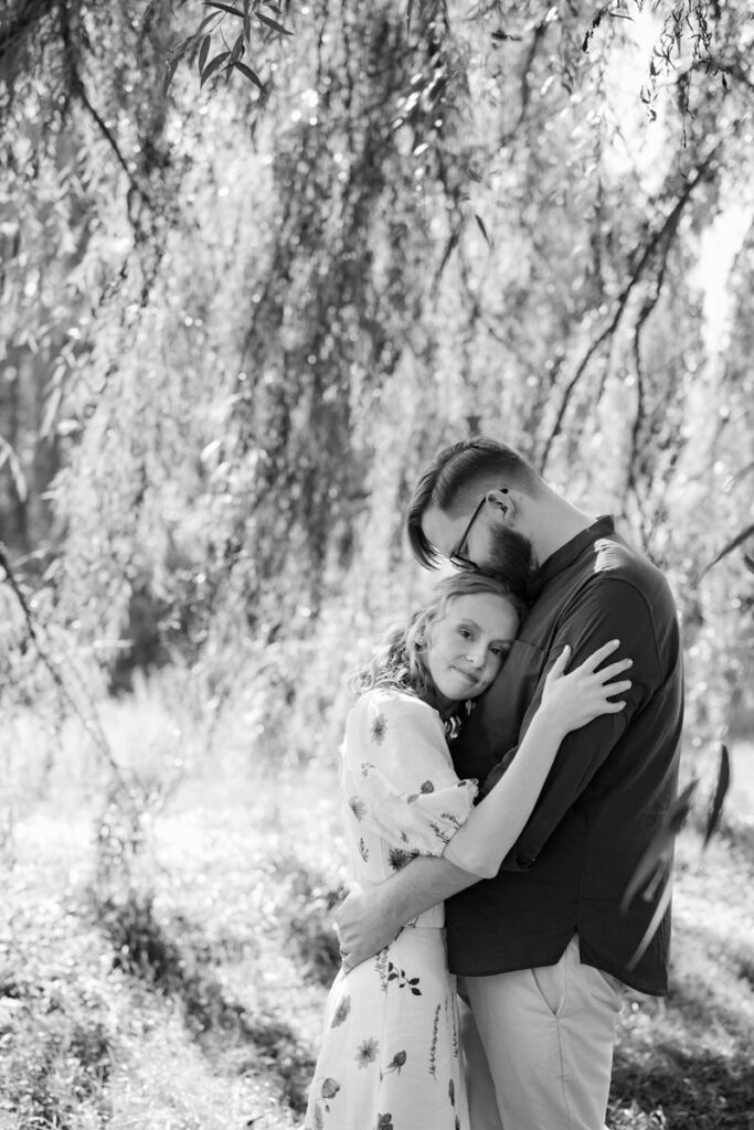 A couple hugging while one kisses the top of the other's head. 