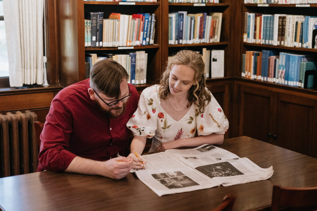 A couple sitting at a table doing a crossword 