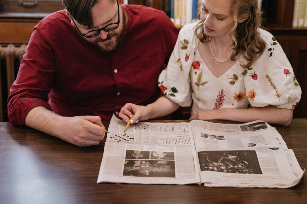 A couple doing a crossword puzzle at a table 