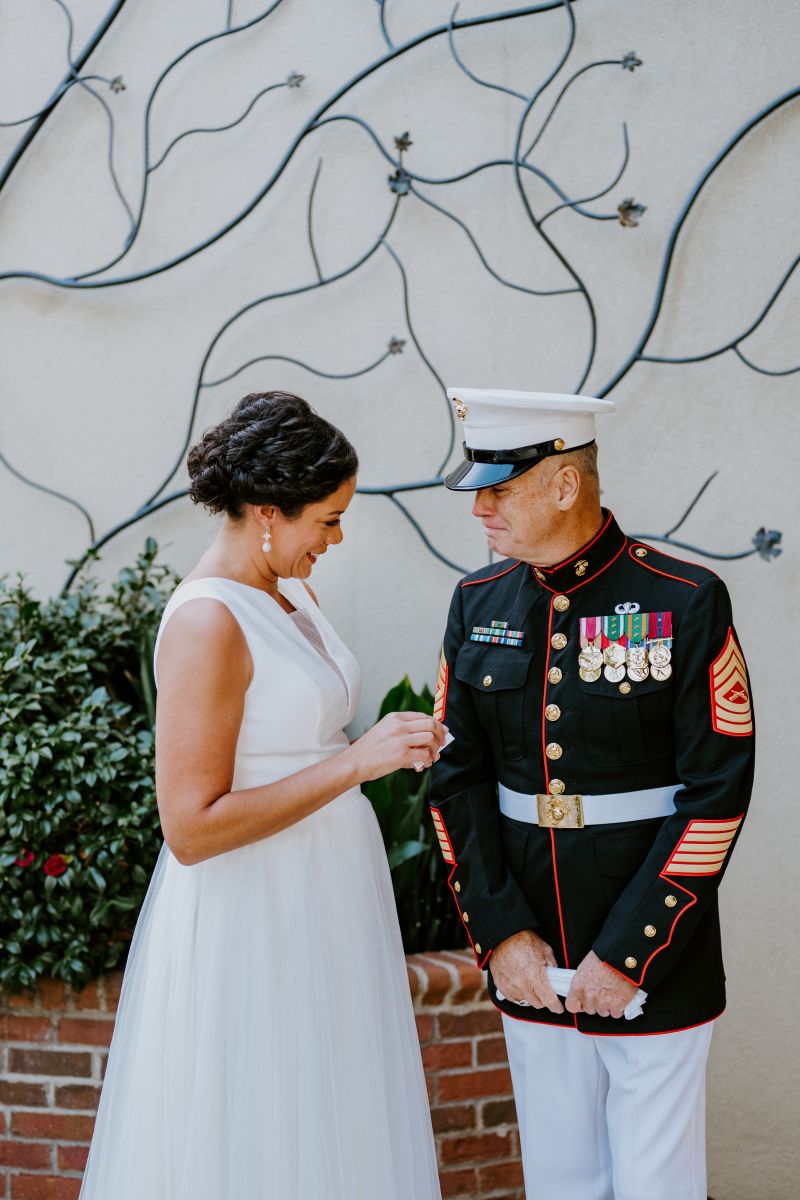 A woman in a white wedding dress doing a first look with her father 