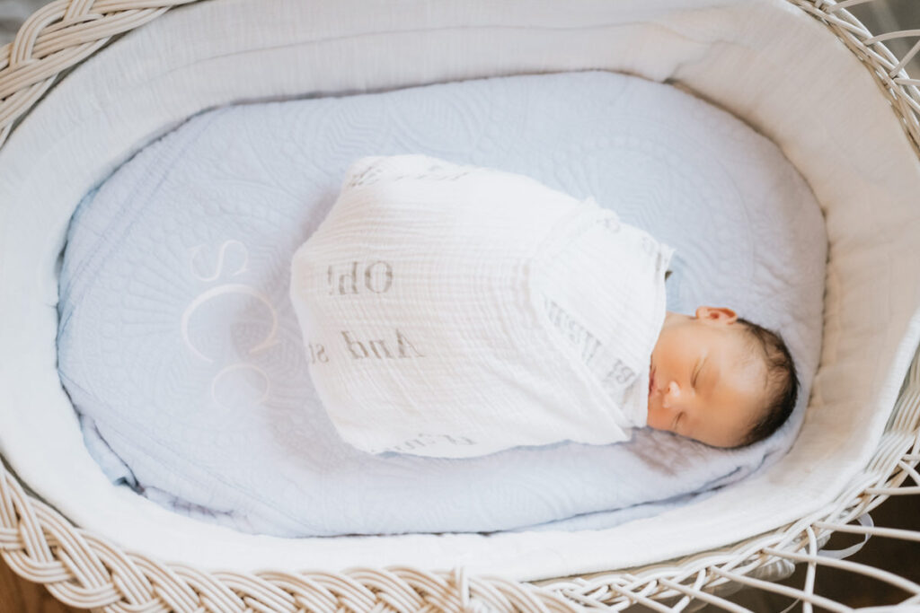 A newborn swaddled in a bassinet 